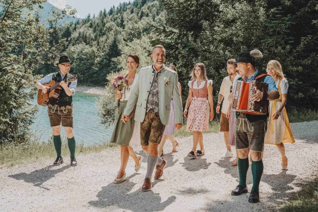 Hochzeit Gesellschaft geht am See entlang zum Almstadl am Schwarzensee.